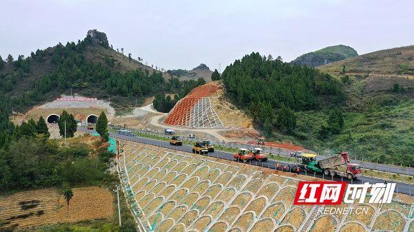 在新田县龙泉街道石甄源村路段,压路机,沥青摊铺机来回作业,施工现场