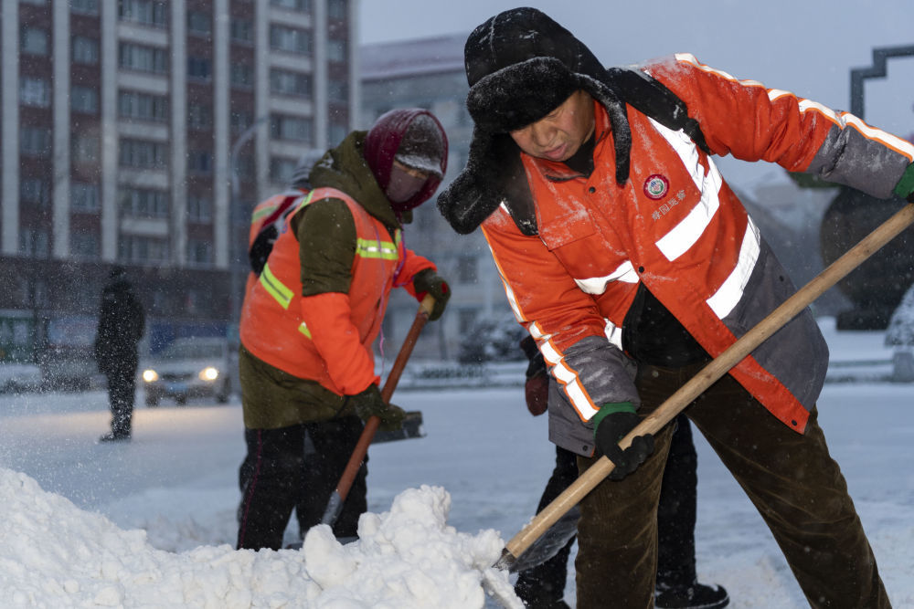 11月22日,环卫工人在鹤岗市街道上进行清雪作业.