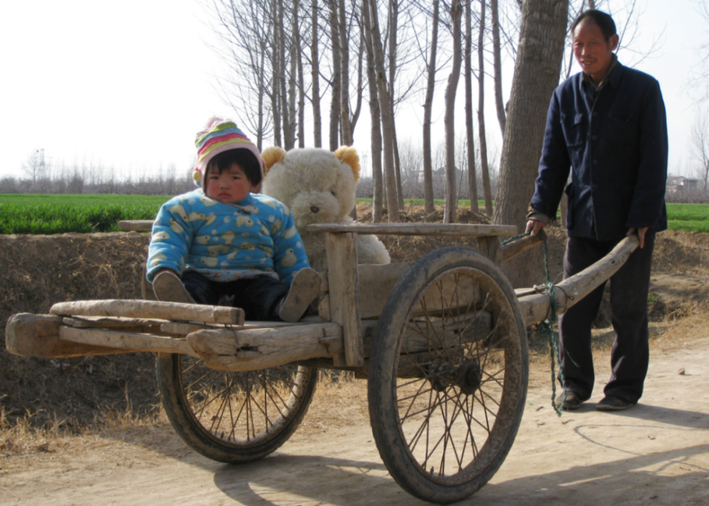 二三十年前乡村的冬天,看孩子的家长,也会拉着平板车(架子车),让孩子
