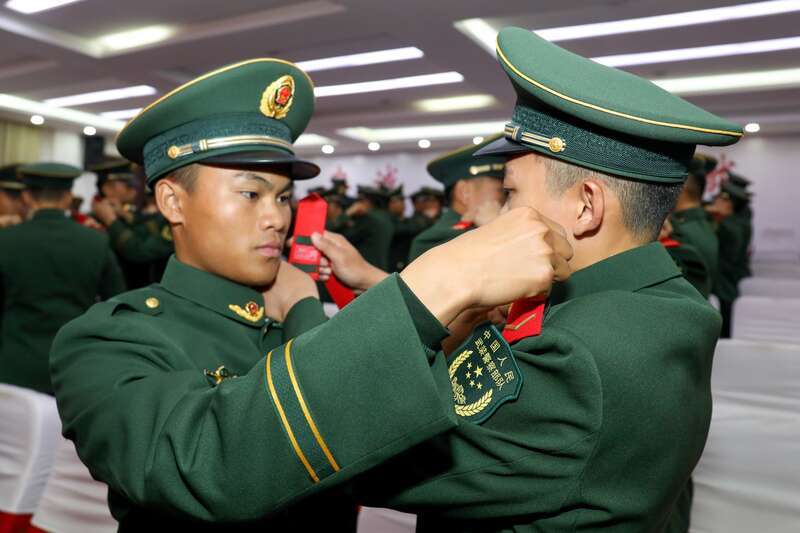 新战士互相佩戴列兵军衔 来源:中国青年报客户端