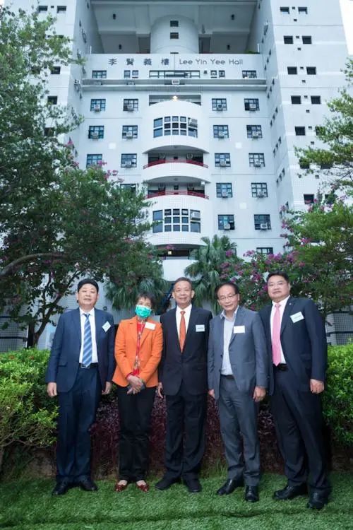 信义能源控股有限公司主席李圣泼(右一)等在「李贤义楼」前合影李圣泼