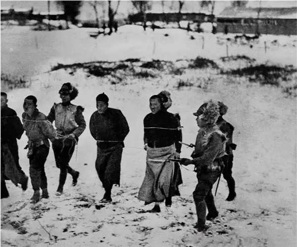 这张照片拍摄于1932年的东北新民屯地区,画面中这几位被捆绑着,正在
