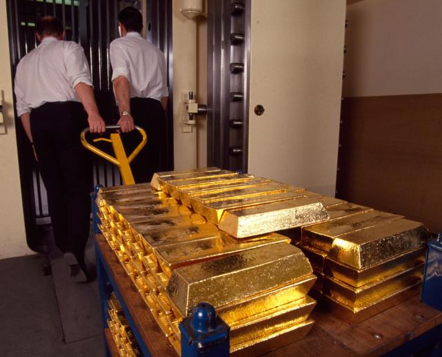 波兰官员在银行金库前拿着实物黄金条上周,波兰央行行长接受了波兰