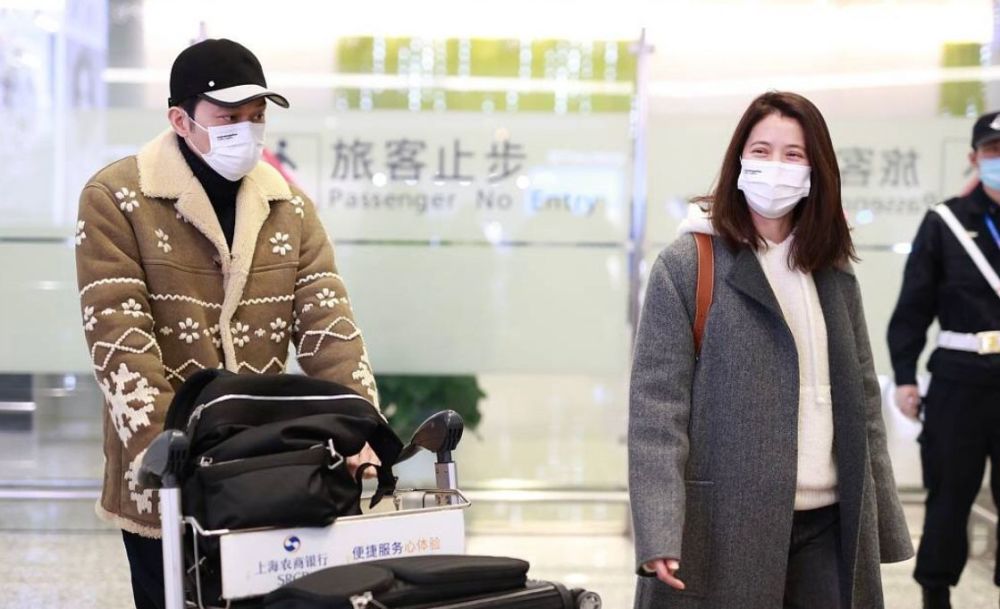 袁咏仪很习惯随便，素颜在机场走也不在意。 张智霖穿着6万件大衣很时髦