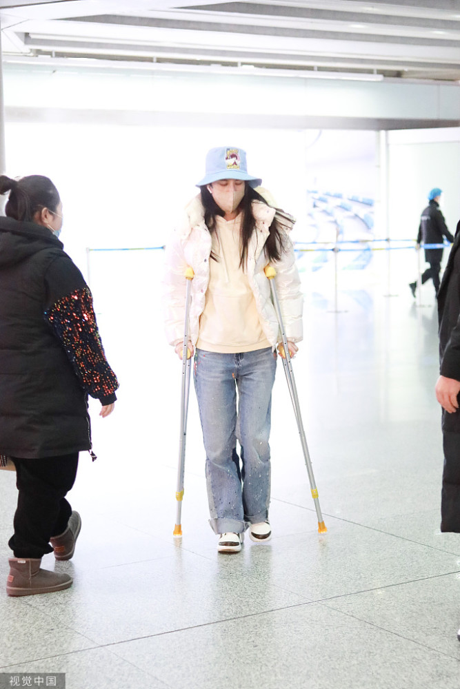 演员黄圣依拄拐杖现身北京机场