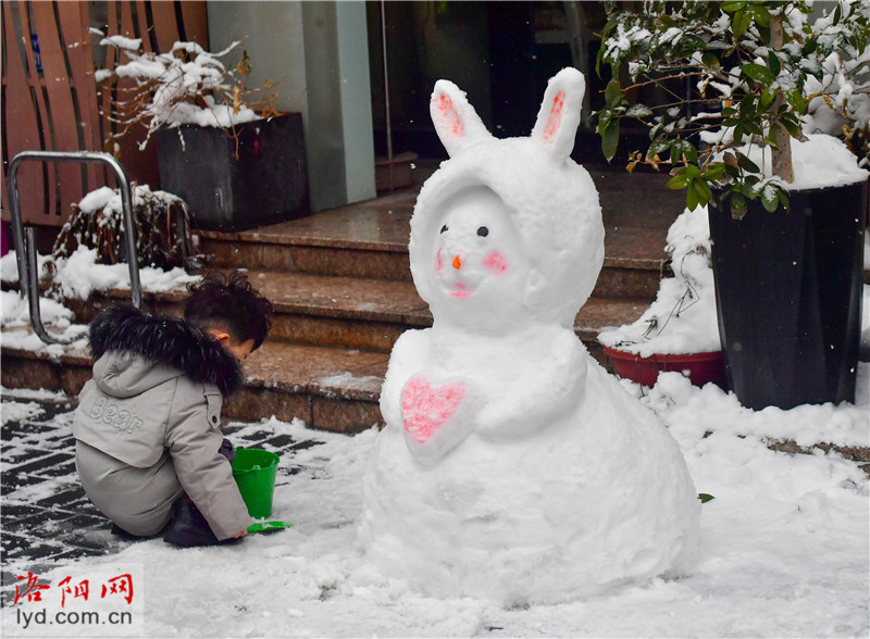 戴口罩的雪人熊猫在孟津区小浪底大道十字路口的"大象