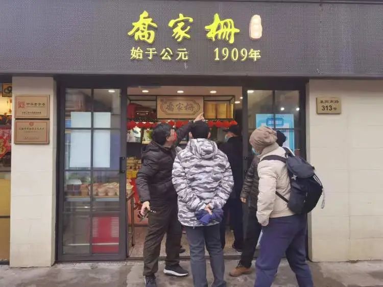 "刘阿婆手里拎着两大包写有邵万生字样的手提袋走出店来.