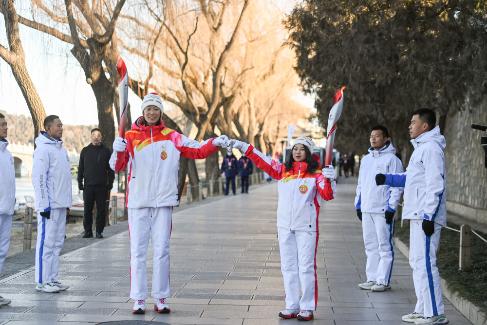 2月4日,火炬手林诗凌(右)与朱婷进行火炬传递.新华社记者 陈晔华 摄