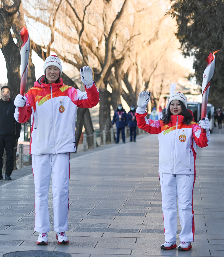 2月4日,火炬手林诗凌(右)与朱婷进行火炬传递.