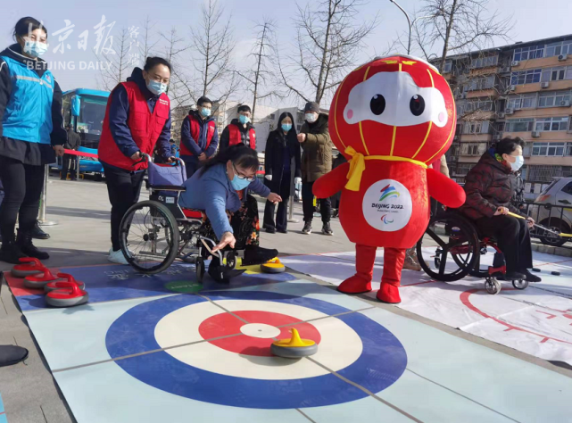 进行旱地冰壶,冰球的体验并和冬残奥会吉祥物"雪容融"合影,让辖区残疾