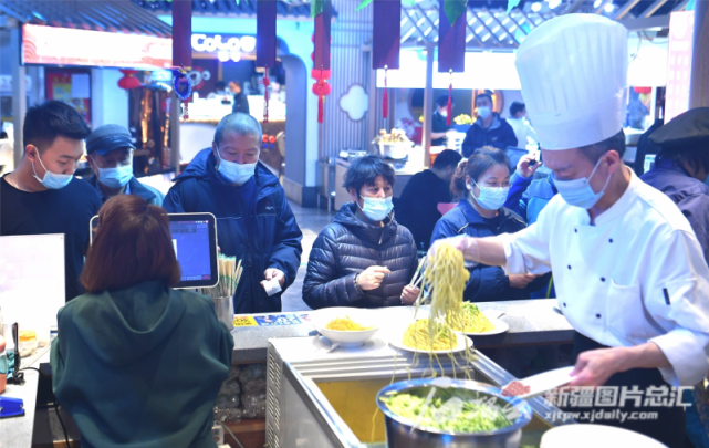 3月18日,位于乌鲁木齐市中山路上的百花村餐饮广场,市民在百花村凉面