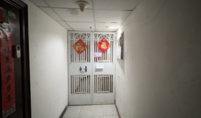 北京一小区私装铁门圈占楼道,门内杂物堆放一人高