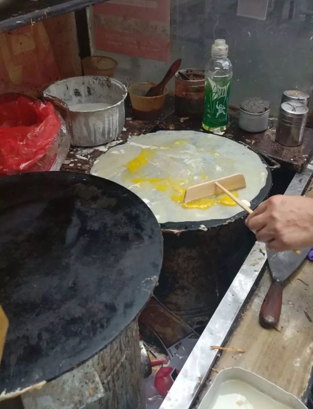 防寒保暖兼具卫生功能的口罩,令冬日里推着煎饼车的大妈化身为蒙面