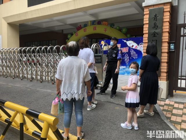 金门路小学门前,前来报名的学生不多,少量家长带孩子等候孩子跟着家长