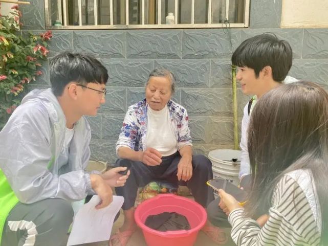 村民带小孩观看植保学院的科普宣传展板(李羲摄)调研实践团元阳站的