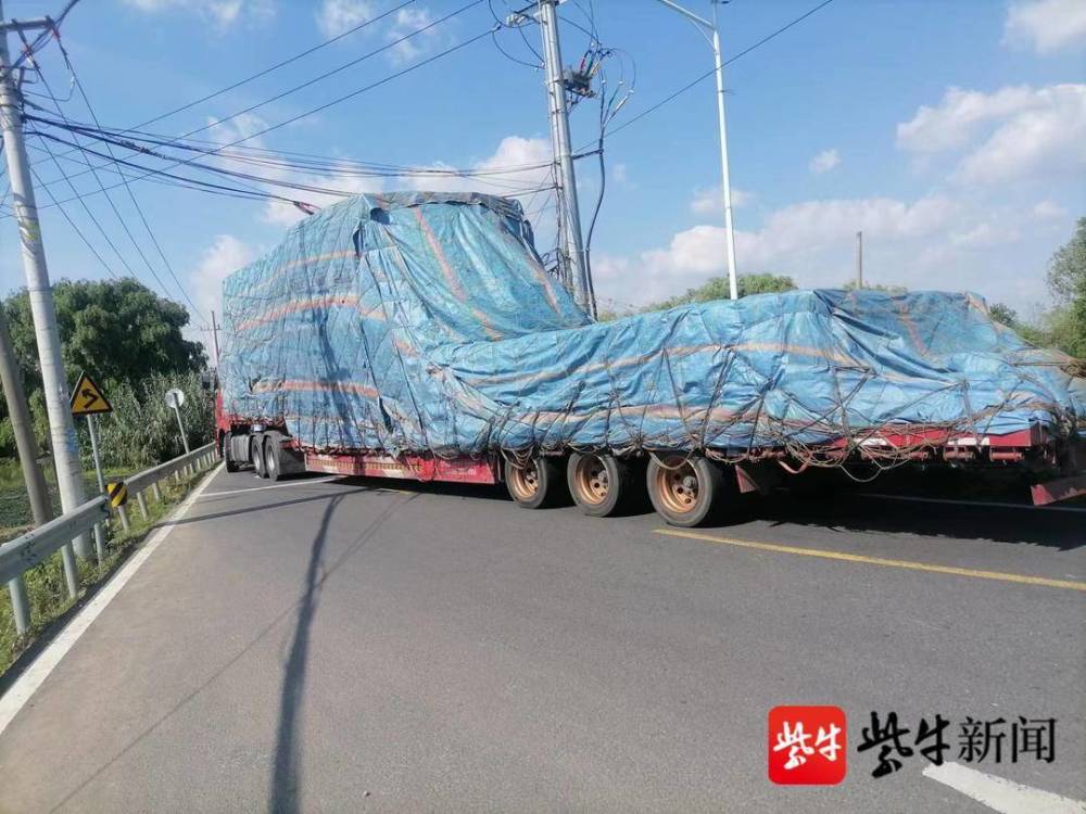 道路不熟误入窄路满载的大货车被困路口