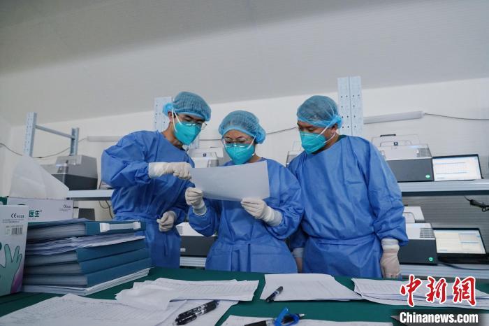 图为身着防护服的工作人员在胶囊气膜实验室内忙碌.
