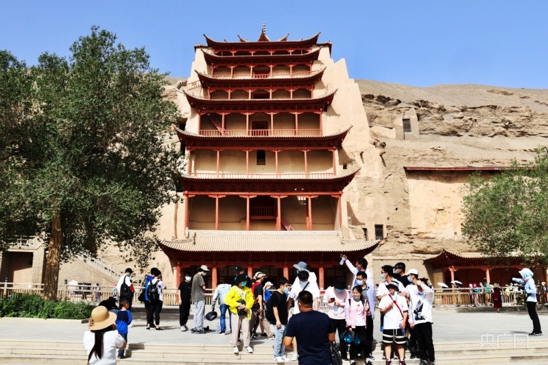 游客在敦煌莫高窟九层楼前拍照留念(央广网发 李红军 摄)20世纪90