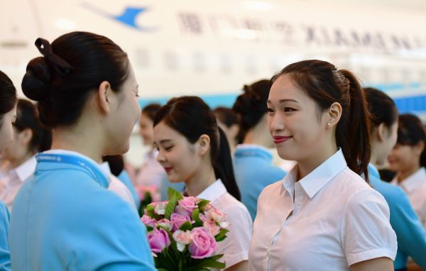 8月16日，首批台湾籍空中乘务员（右）接受厦航空中乘务员送上的欢迎鲜花。新华社记者 魏培全 摄