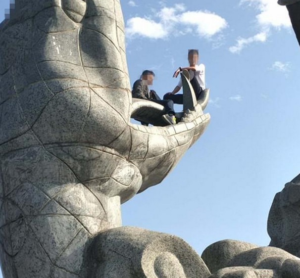 岳阳巴陵广场俩男子攀爬16米高雕像 趴在上面