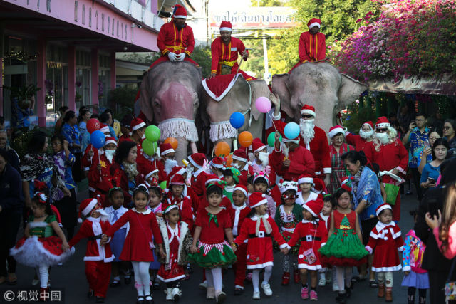 泰国圣诞老人骑大象游行 为沿街儿童发放礼物