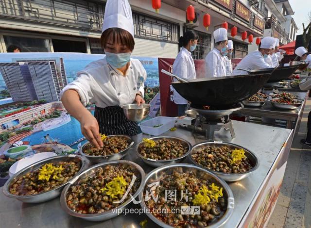 3月24日,江苏省淮安市洪泽区蒋坝镇螺蛳美食节上,厨师在给螺蛳装.