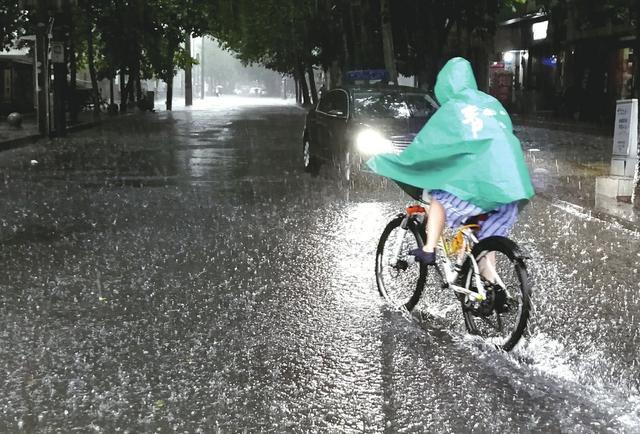 7月11日,成都市民在风雨中出行.