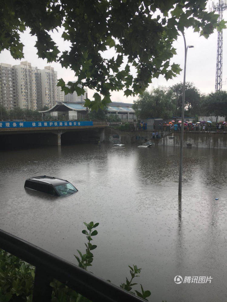 一辆黑色小汽车只露出车顶。