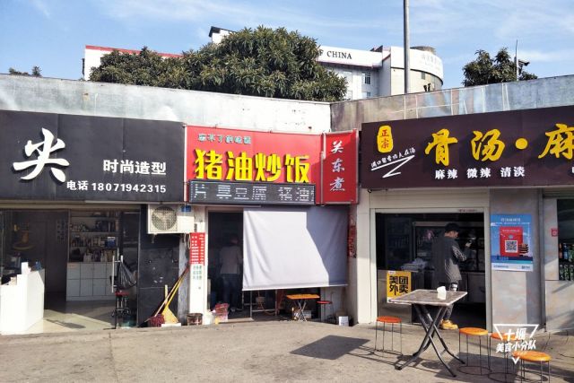 普通的红色底门头,黄字招牌,店里内有乾坤,家庭式的桌凳,人来人去,有