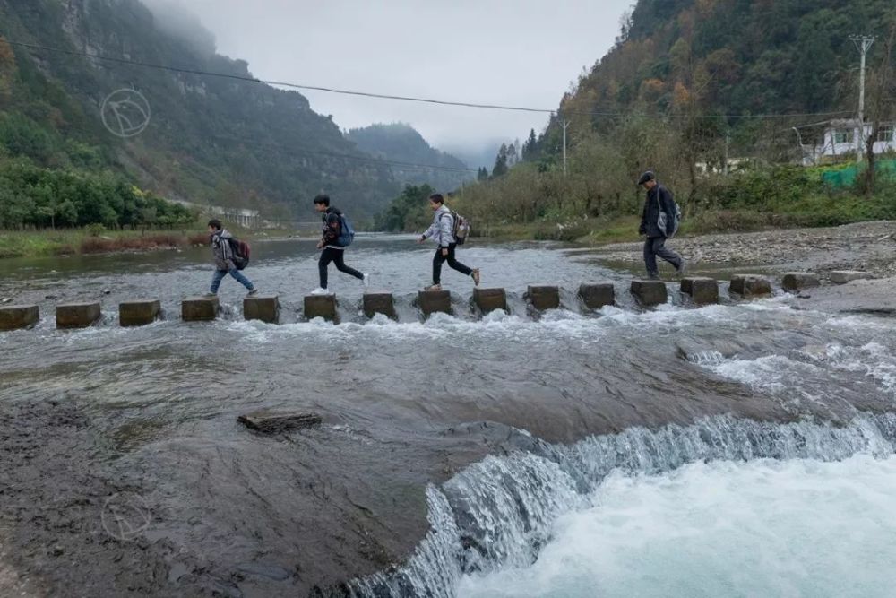 安忠民带着孩子们走过段溪河的跳墩,就到了通往乡上的公路.