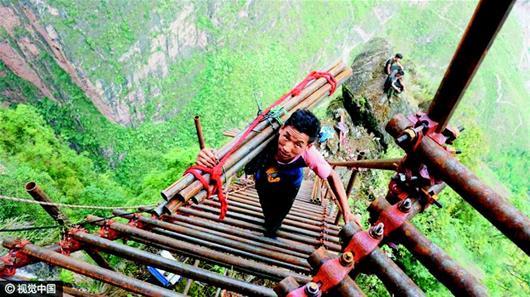 凉山"悬崖村"绝壁修路 村民背钢管造天梯