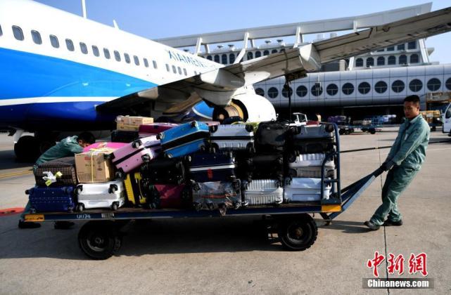 装卸工在狭窄的飞机货仓里搬运行李 王东明 摄