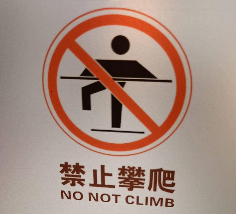 粤海仰忠汇2楼玻璃上的提示牌 将禁止攀爬翻译成 no not climb 而正确