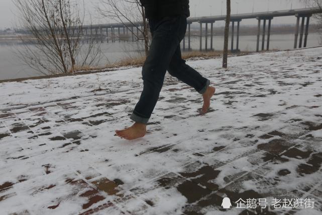 日上午,在河南省偃师市公园内,今年51岁的王长乐光脚在雪地里跑步锻炼