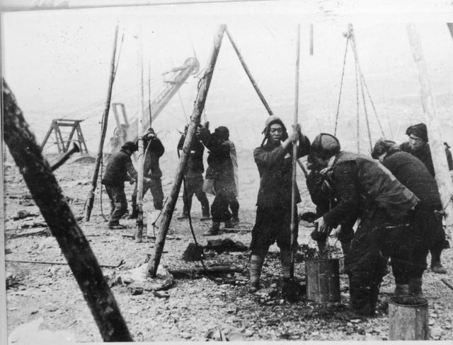 1948年12月,抚顺露天矿工人在人工钻爆破孔.