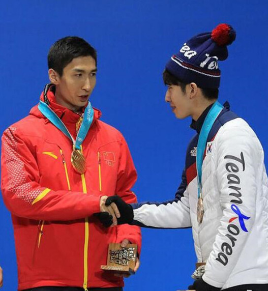 武大靖与韩国选手林孝俊在平昌冬奥会颁奖礼上互动 资料图