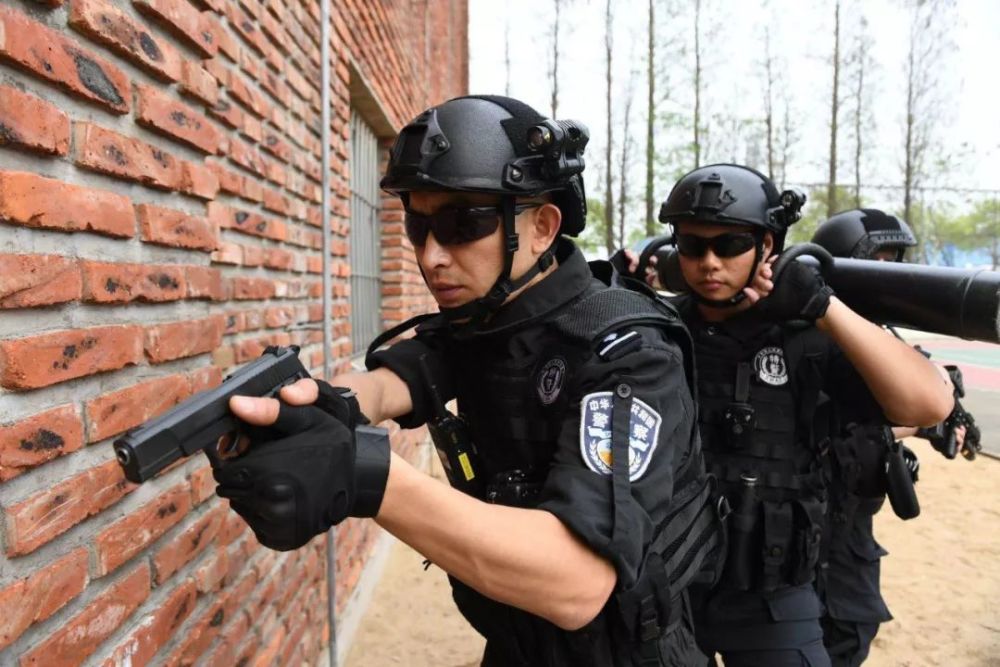 b组特警迅速组成战术队形沿楼道,运用声光盾牌,破门锤等特种器械进行