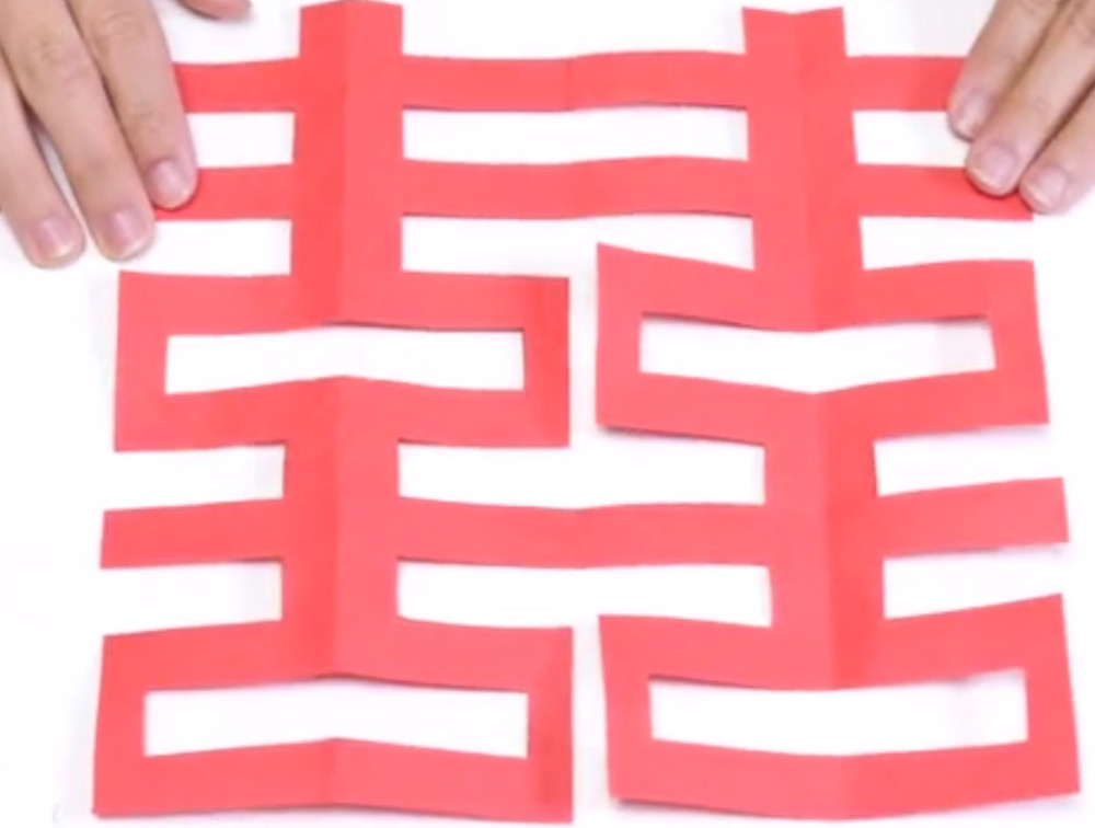 第3种,也是心形的喜字,首先第1步也是准备对折的,红纸折好后画出如下