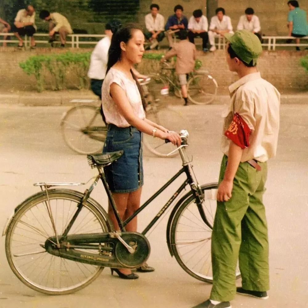 年代人们对于交通安全意识还没有那么强烈,上图这位女孩正骑自行车在
