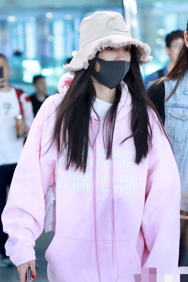 杨幂口戴帽子口罩低调现身机场 粉卫衣搭白色健美裤少女感十足