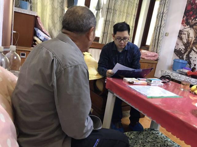 伍主任用心查看老人的病历资料及了解用药情况