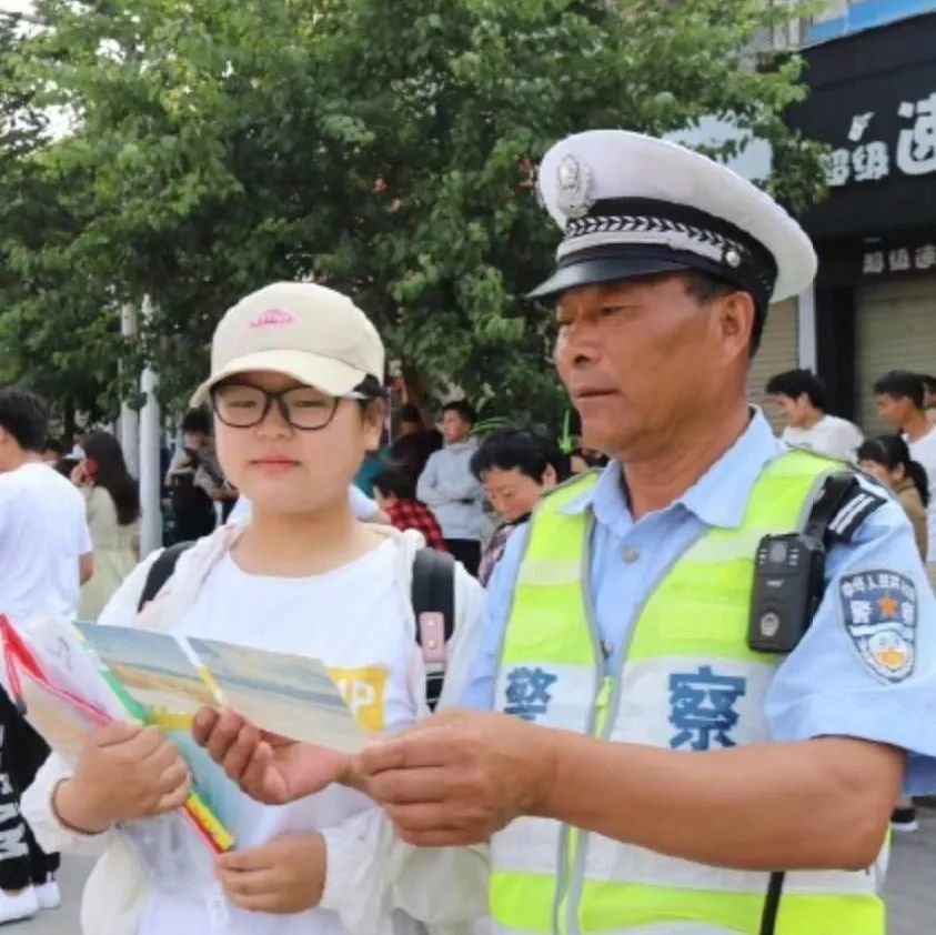 池州市第十中学门前,一位考生向池州市公安局交警支队民警求助.