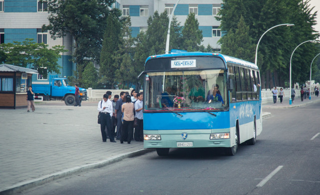 图为朝鲜平壤街头的一辆无轨电车,很多朝鲜百姓正在排队上车.