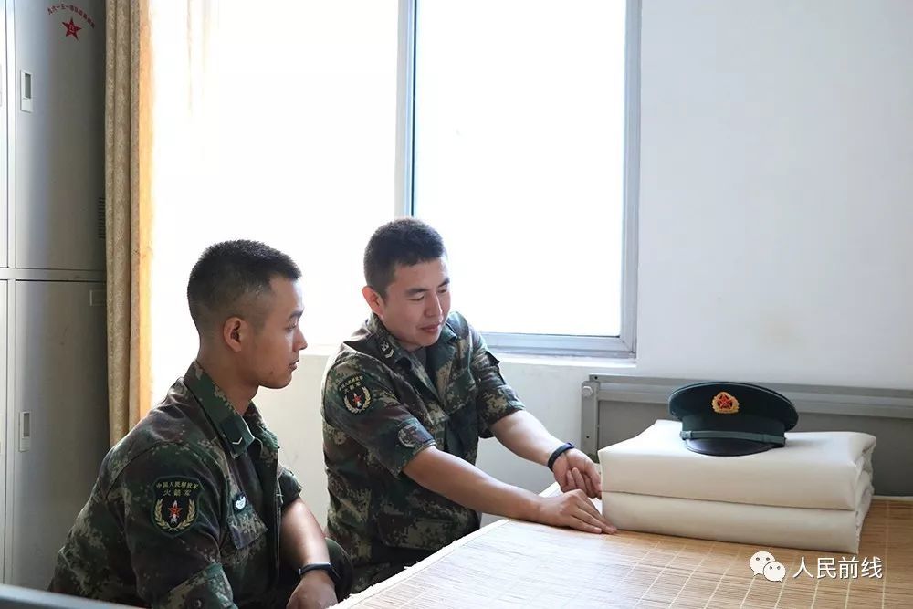 炊事班班长张鼎名正在教新同志整理内务.
