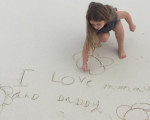 萌化了！小七沙滩上手写告白信：我爱爸爸妈妈