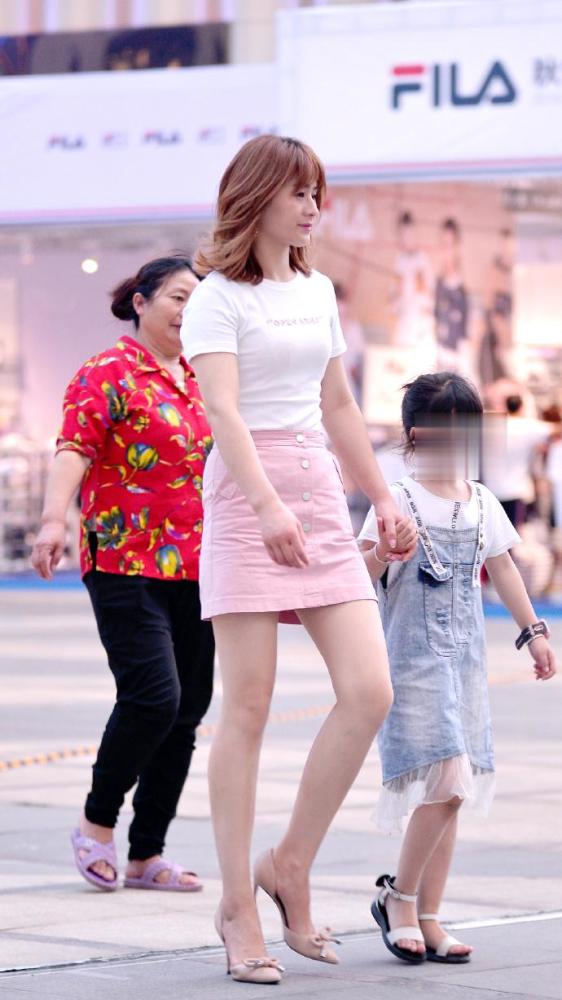 路人街拍:时尚辣妈牵手女儿走在街头,穿粉裙彰显时髦减龄感!