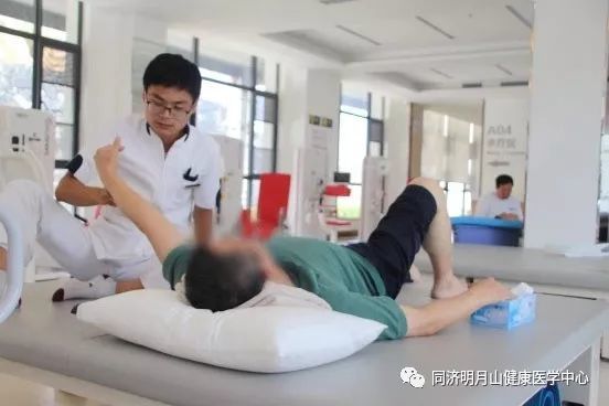 (康复师为患者进行运动疗法)