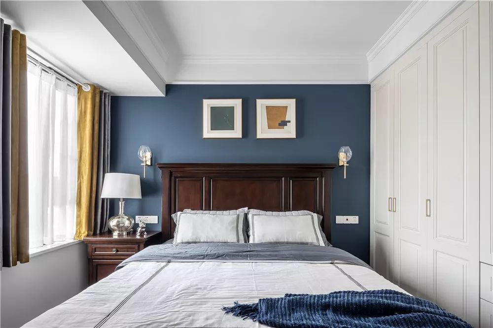 卧室背景墙使用雾霾蓝,墙面经典的美式壁灯,消除单色的枯燥和分散