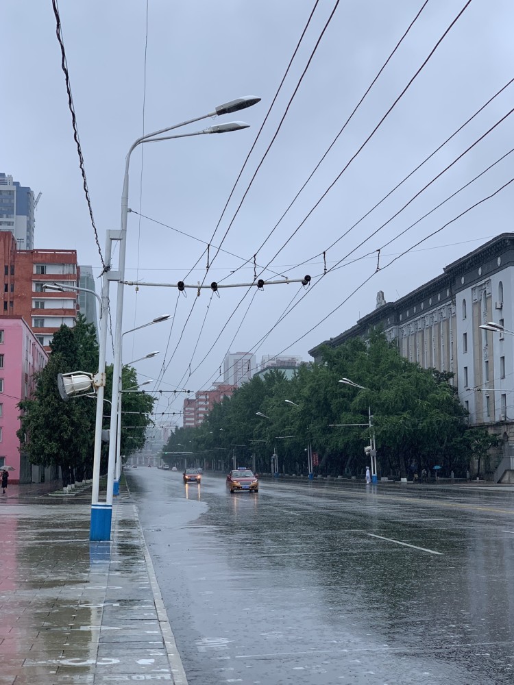 图为平壤的雨天,两名出租车行驶在马路上.