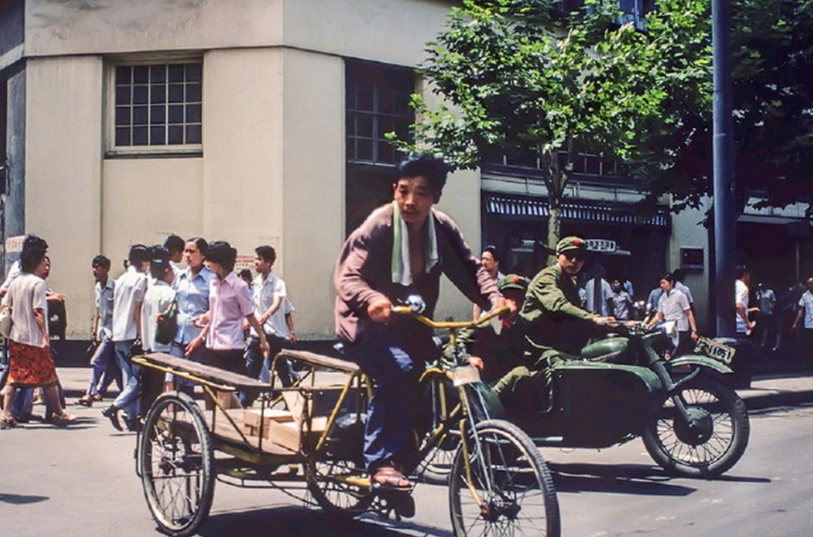 蹬三轮的群众和骑侧三轮摩托车的解放军战士.